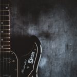 a black electric guitar with a black background