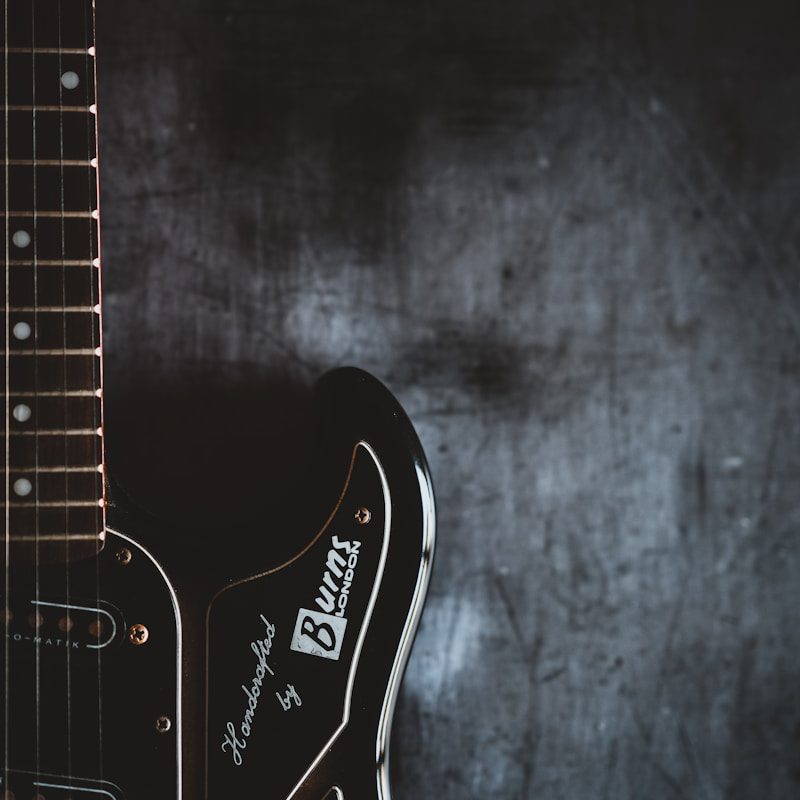 a black electric guitar with a black background