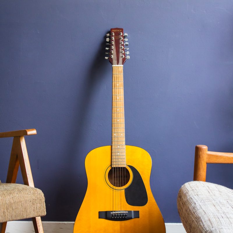 yellow acoustic guitar leaning on wall